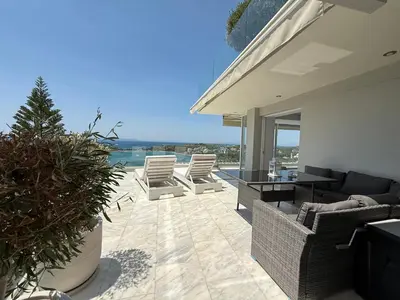 a house with a patio with chairs and a view of the ocean at Dream View Vouliagmeni in Athens