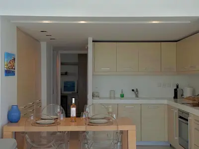 a kitchen with a table with chairs and a counter top at Dream View Vouliagmeni in Athens