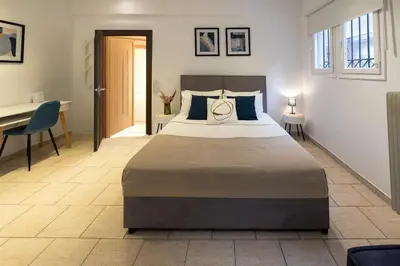 a bedroom with a large bed and a desk in it at Phaedrus Living Athens City Studios Angel in Athens