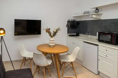 a kitchen with a table and chairs and a microwave at Phaedrus Living Athens City Studios Angel in Athens