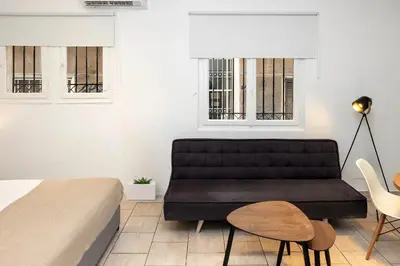 a bedroom with a black couch and a table and chairs at Phaedrus Living Athens City Studios Angel in Athens
