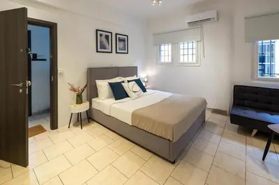a bedroom with a bed and a chair in it at Phaedrus Living Athens City Studios Angel in Athens