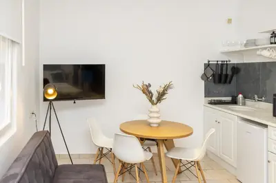 a living room with a table and chairs and a couch at Phaedrus Living Athens City Studios Angel in Athens