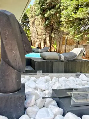 a statue sitting next to a swimming pool with rocks at Ablaze Luxury Athens in Glyka Nera