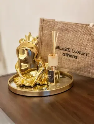 a gold platter with a candle and a bottle of black luxury offers at Ablaze Luxury Athens in Glyka Nera