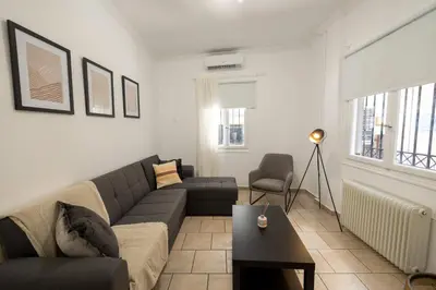 a living room with a couch and a table at Phaedrus Living Athens City Studios Paris in Athens