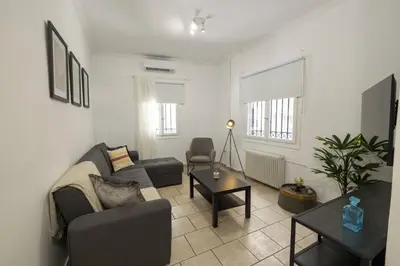a living room with a couch and a table at Phaedrus Living Athens City Studios Paris in Athens