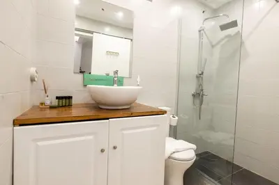 a white bathroom with a sink and a shower at Phaedrus Living Athens City Studios Paris in Athens