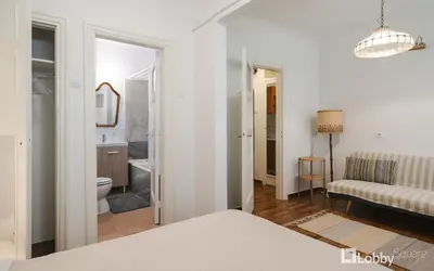 a white room with a couch and a bathroom at Vea Studio Plaka in Athens