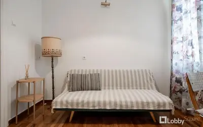 a bed in a room with a table and a lamp at Vea Studio Plaka in Athens