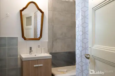 a bathroom with a sink and a mirror and a shower at Vea Studio Plaka in Athens