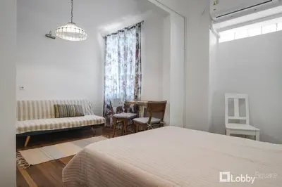 a bedroom with a bed and a couch and a chair at Vea Studio Plaka in Athens