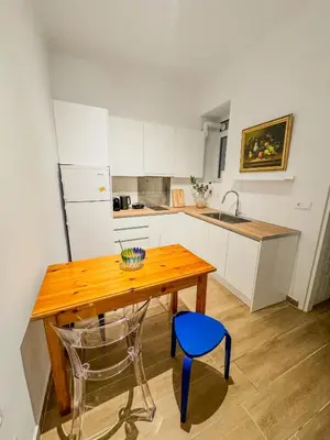 a kitchen with a wooden table and a blue chair at Ανακαινισμένο σπίτι με ιδιωτική αυλή in Piraeus