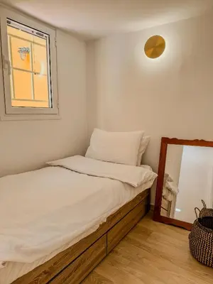 a small bedroom with a bed and a mirror at Ανακαινισμένο σπίτι με ιδιωτική αυλή in Piraeus