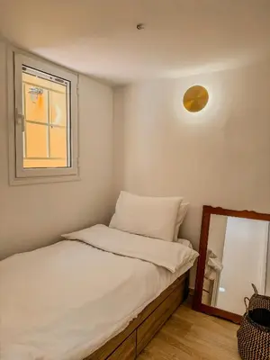 a small bedroom with a bed and a mirror at Ανακαινισμένο σπίτι με ιδιωτική αυλή in Piraeus