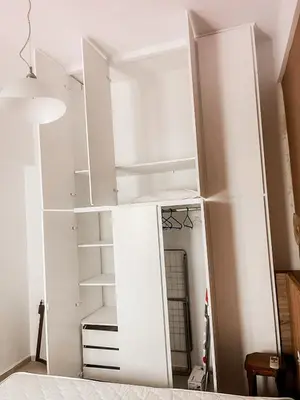 a large white bookcase in a room at Ανακαινισμένο σπίτι με ιδιωτική αυλή in Piraeus