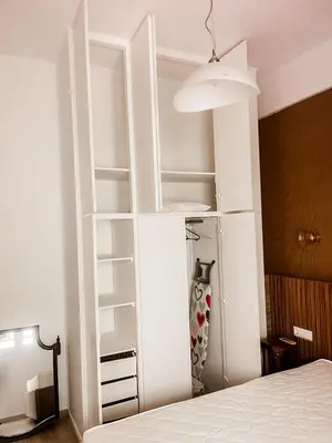 a white book shelf in a bedroom with a bed at Ανακαινισμένο σπίτι με ιδιωτική αυλή in Piraeus