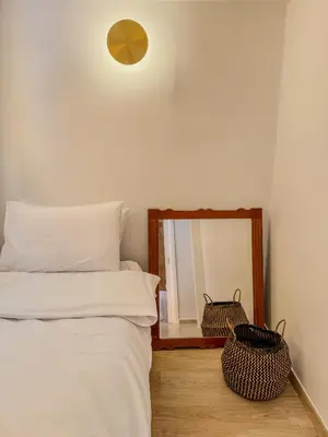 a bedroom with a bed and a mirror at Ανακαινισμένο σπίτι με ιδιωτική αυλή in Piraeus