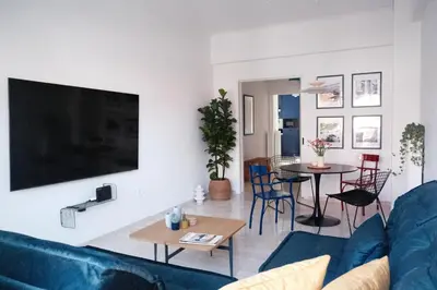 a living room with a blue couch and a table at Unique 2BD Design Apt with airconditioning near Acropolis in Athens