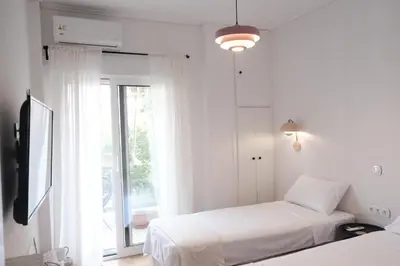 a white room with two beds and a window at Unique 2BD Design Apt with airconditioning near Acropolis in Athens