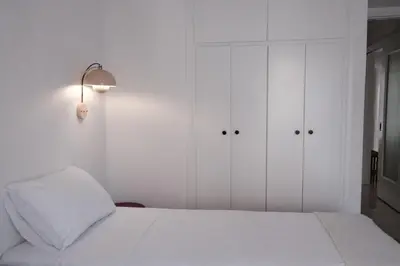 a white bedroom with white cabinets and a bed at Unique 2BD Design Apt with airconditioning near Acropolis in Athens
