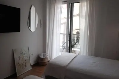 a bedroom with a white bed and a window at Unique 2BD Design Apt with airconditioning near Acropolis in Athens