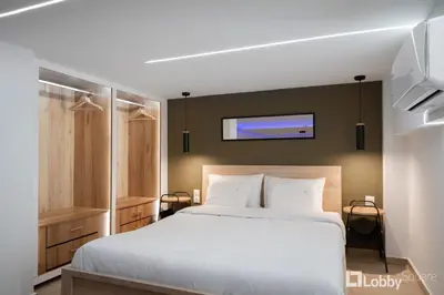 a bedroom with a white bed and a tv on the wall at CityLiv Concept in Athens