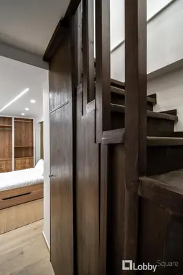 a wooden door in a bedroom with a bed at CityLiv Concept in Athens