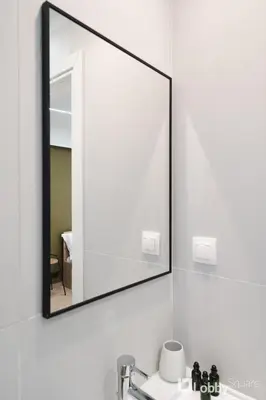 a mirror on a wall above a bathroom sink at CityLiv Concept in Athens