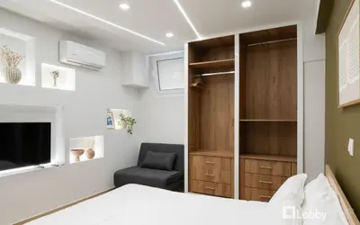 a bedroom with a bed and a chair at CityLiv Concept in Athens