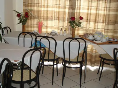 a dining room with a table with chairs and flowers at Elite Hotel in Athens