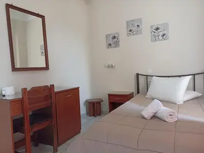 a bedroom with a bed and a desk and a mirror at Elite Hotel in Athens