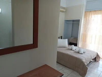 a bedroom with a bed with a mirror and a window at Elite Hotel in Athens