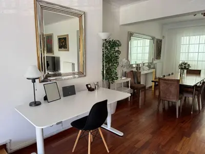 a living room with a white table and a mirror at Vouliagmeni Seaside Escape in Athens
