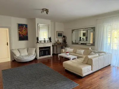 a living room with a white couch and a fireplace at Vouliagmeni Seaside Escape in Athens