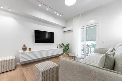a living room with a couch and a tv on a wall at Phaedrus Living Prosperity Residences Paradise in Athens