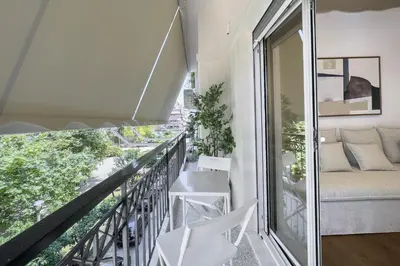 a balcony with white chairs and a couch at Phaedrus Living Prosperity Residences Paradise in Athens