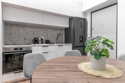 a kitchen with a wooden table with a potted plant at Phaedrus Living Prosperity Residences Paradise in Athens