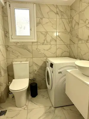 a bathroom with a washing machine and a toilet at Walk into Dream of Acropolis 11 in Athens