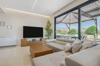 a living room with a couch and a flat screen tv at Penthouse Sauna & Jacuzzi in Glyfada in Athens