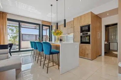 a kitchen with a bar with blue bar stools at Penthouse Sauna & Jacuzzi in Glyfada in Athens