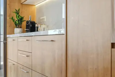 a kitchen with wooden cabinets and a counter at Penthouse Sauna & Jacuzzi in Glyfada in Athens
