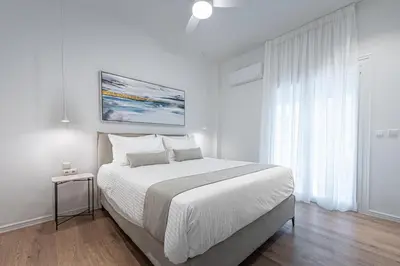 a white bedroom with a large bed and a window at Phaedrus Living Prosperity Residences Harmony in Athens
