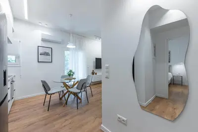 a living room with a table and chairs and a mirror at Phaedrus Living Prosperity Residences Harmony in Athens