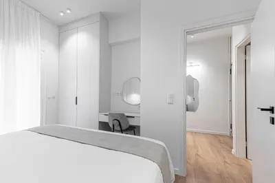 a white bedroom with a bed and a desk at Phaedrus Living Prosperity Residences Harmony in Athens