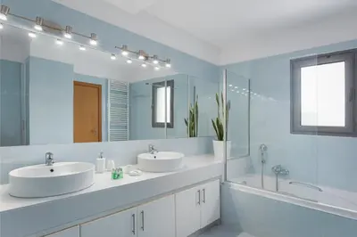 a bathroom with two sinks and a large mirror at Grand Apollon Villa in Sounio