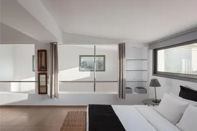 a bedroom with a large bed and a window at Grand Apollon Villa in Sounio