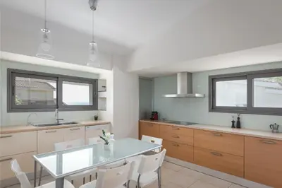 a kitchen with a glass table and white chairs at Grand Apollon Villa in Sounio