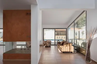 a living room with a couch and large windows at Grand Apollon Villa in Sounio
