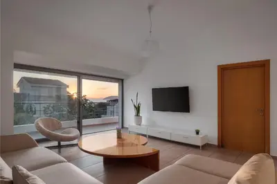 a living room with a couch and a table at Grand Apollon Villa in Sounio